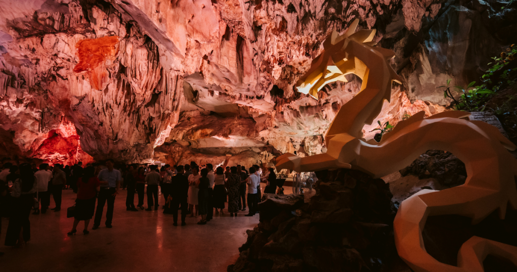 Tourists exploring Dragon Pearl Cave limestone formations before the dining show — Quang Ninh Vietnam